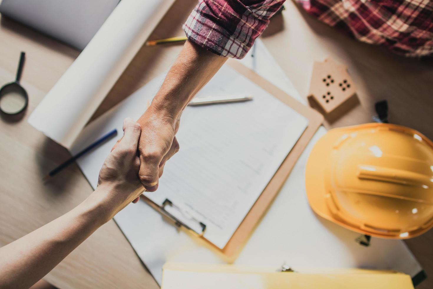 an-engineer-and-building-contractor-shake-hands-over-a-construction-bid-free-photo